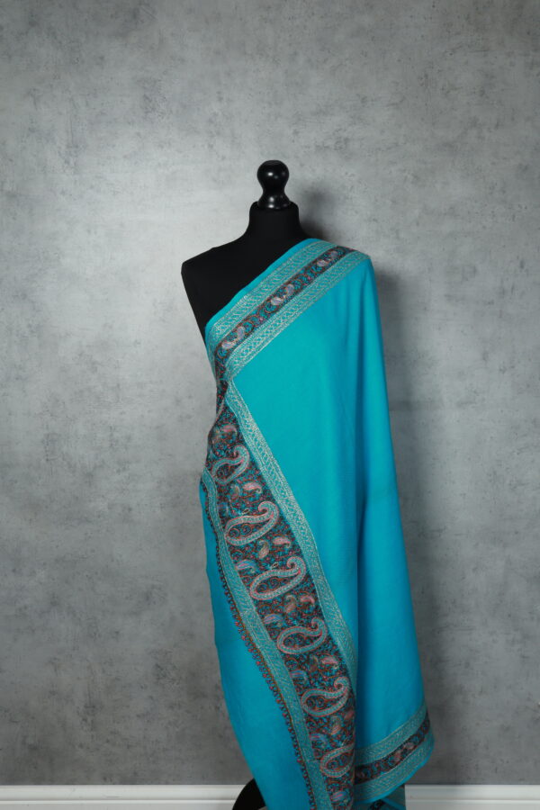 EmbroCrest Shawl in Sky, featuring intricate Kashmiri pashmina embroidery with a crest-like border, crafted from 100% wool.
