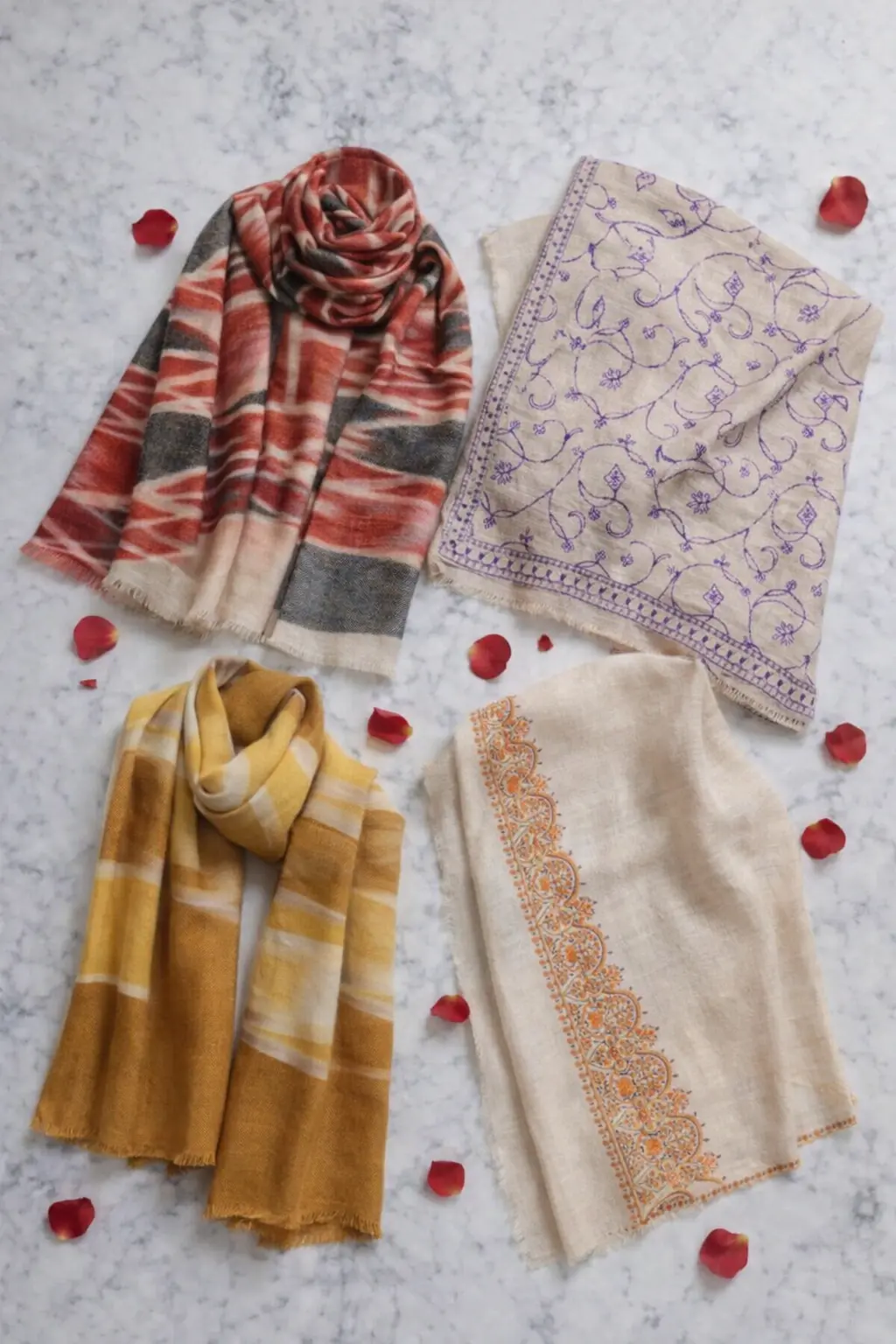 Quad-Layout Product Showcase of Assorted Artisanal Shawls on Marble Surface.